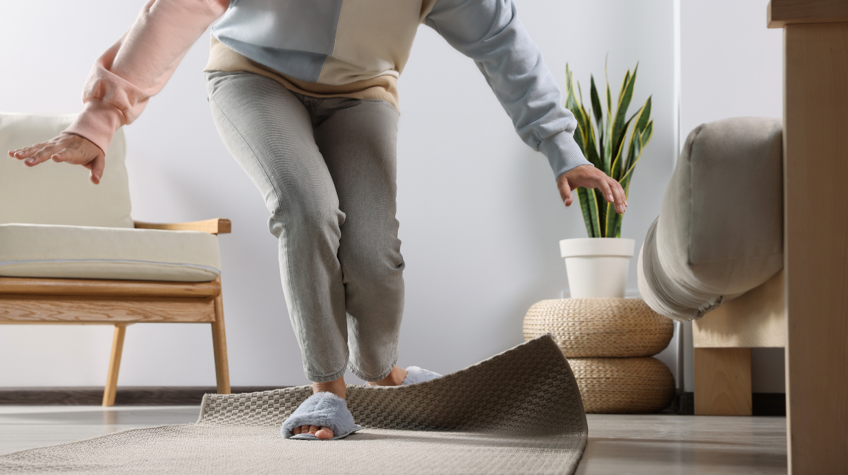 Senior woman tripping over a rug