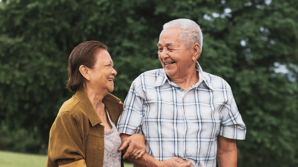 Senior couple walking outside and smiling at each other