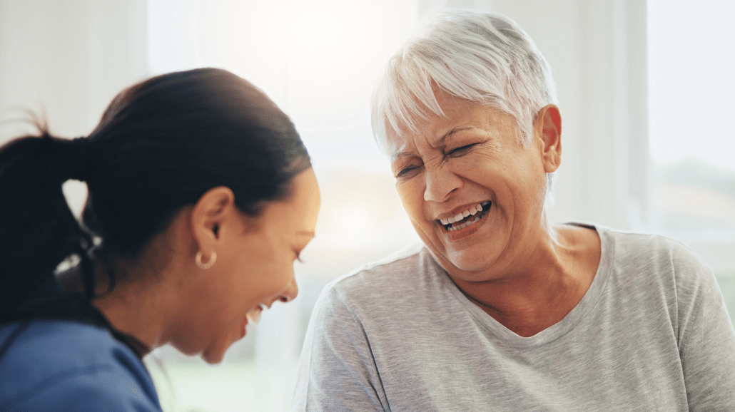 Senior woman laughing with her caregiver
