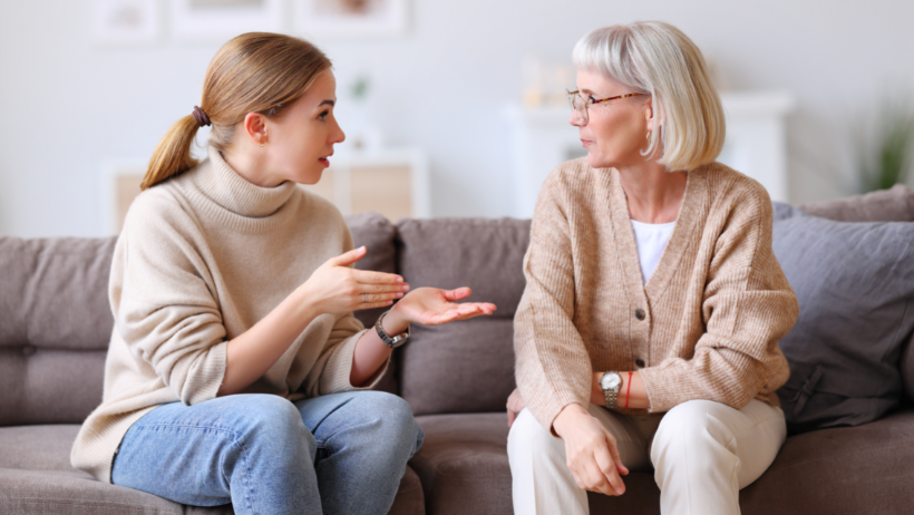 Elderly woman talking to her adult child in the living room