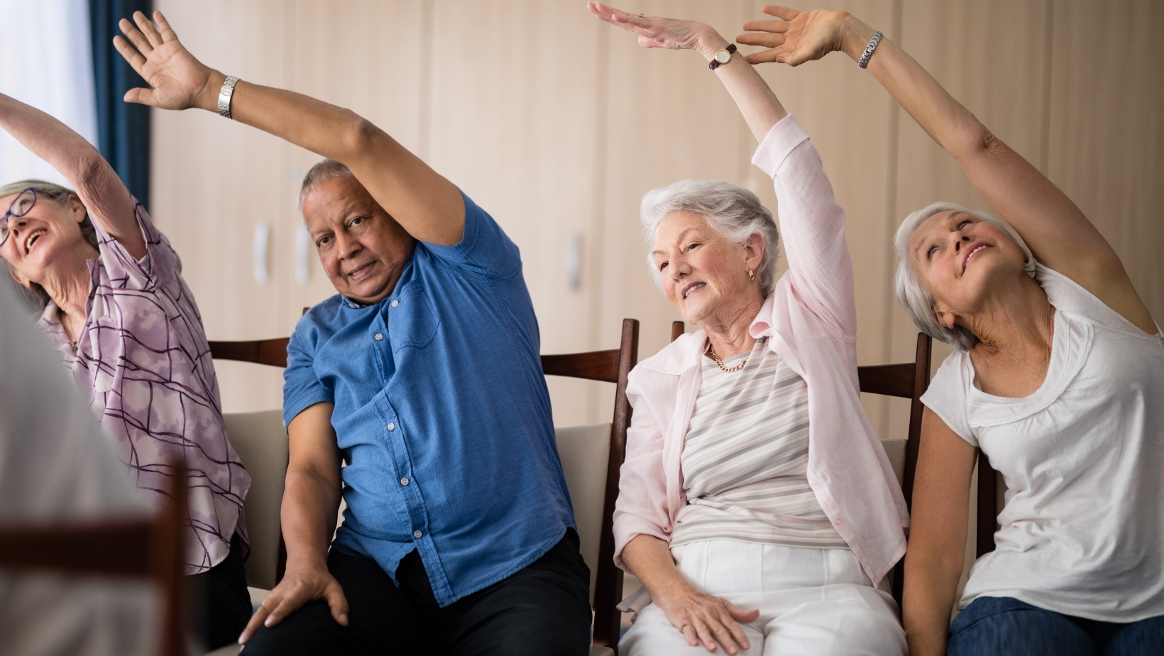 Group of seniors stretching during chair exercises
