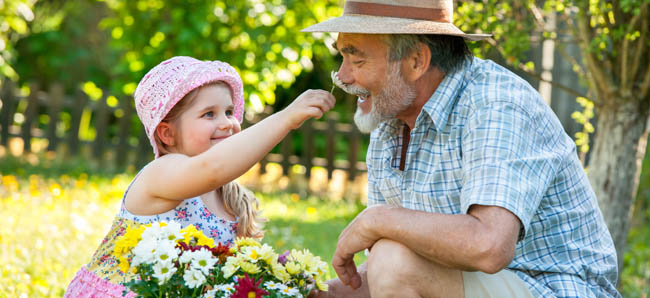 Happy grandfather with his granddaughter in the garden
