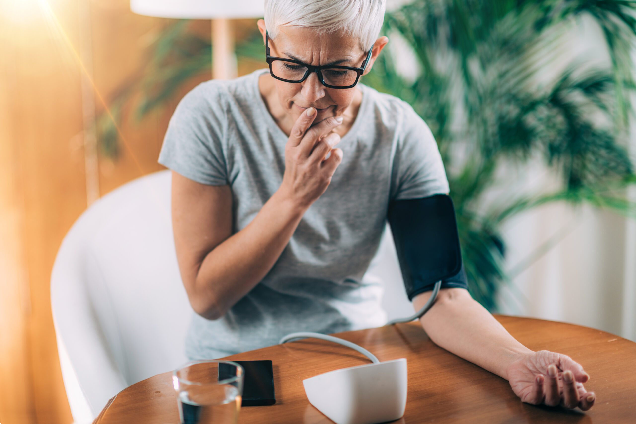 Woman measuring her blood pressure at home