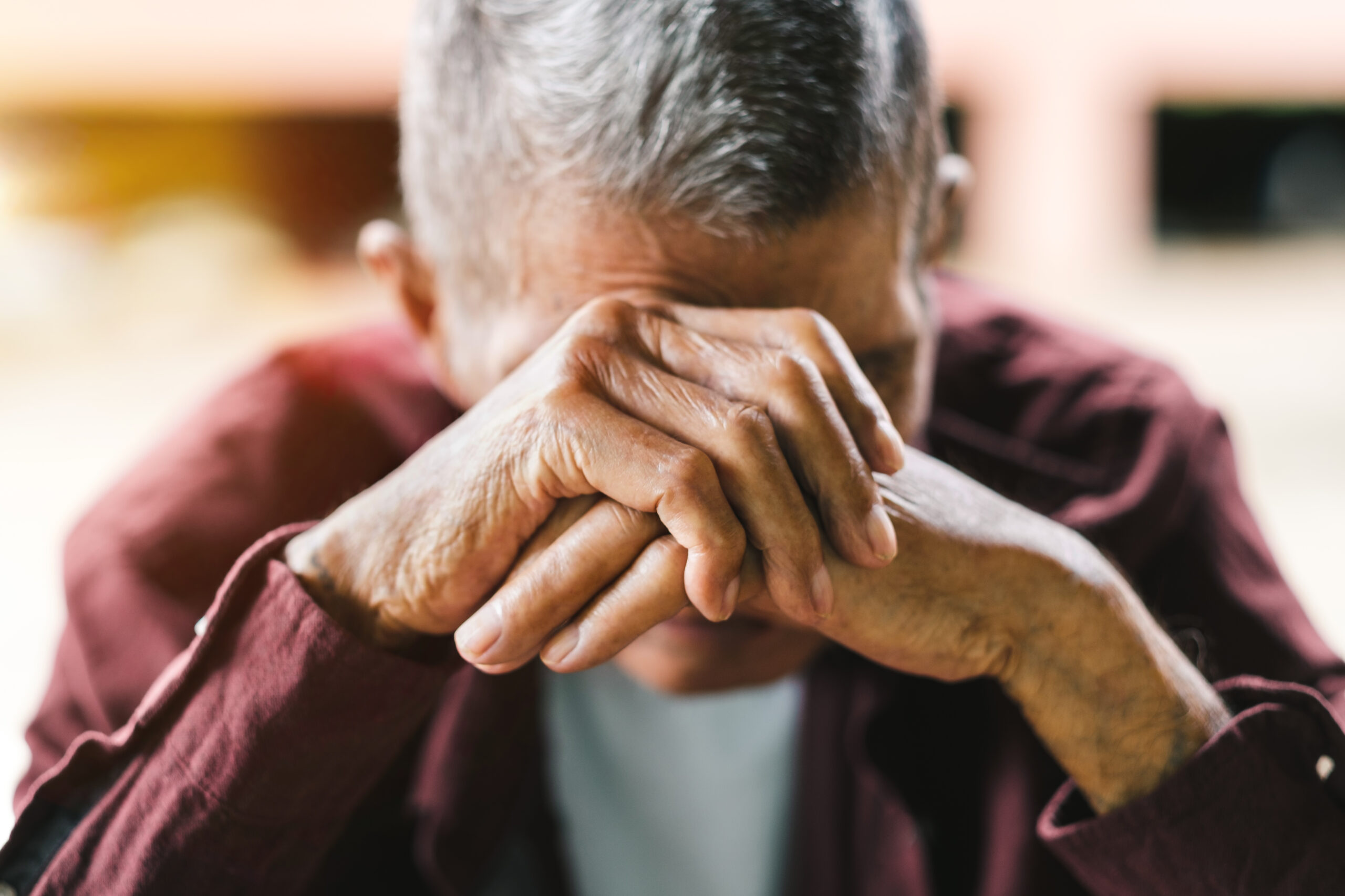 senior man covering his face with his hands