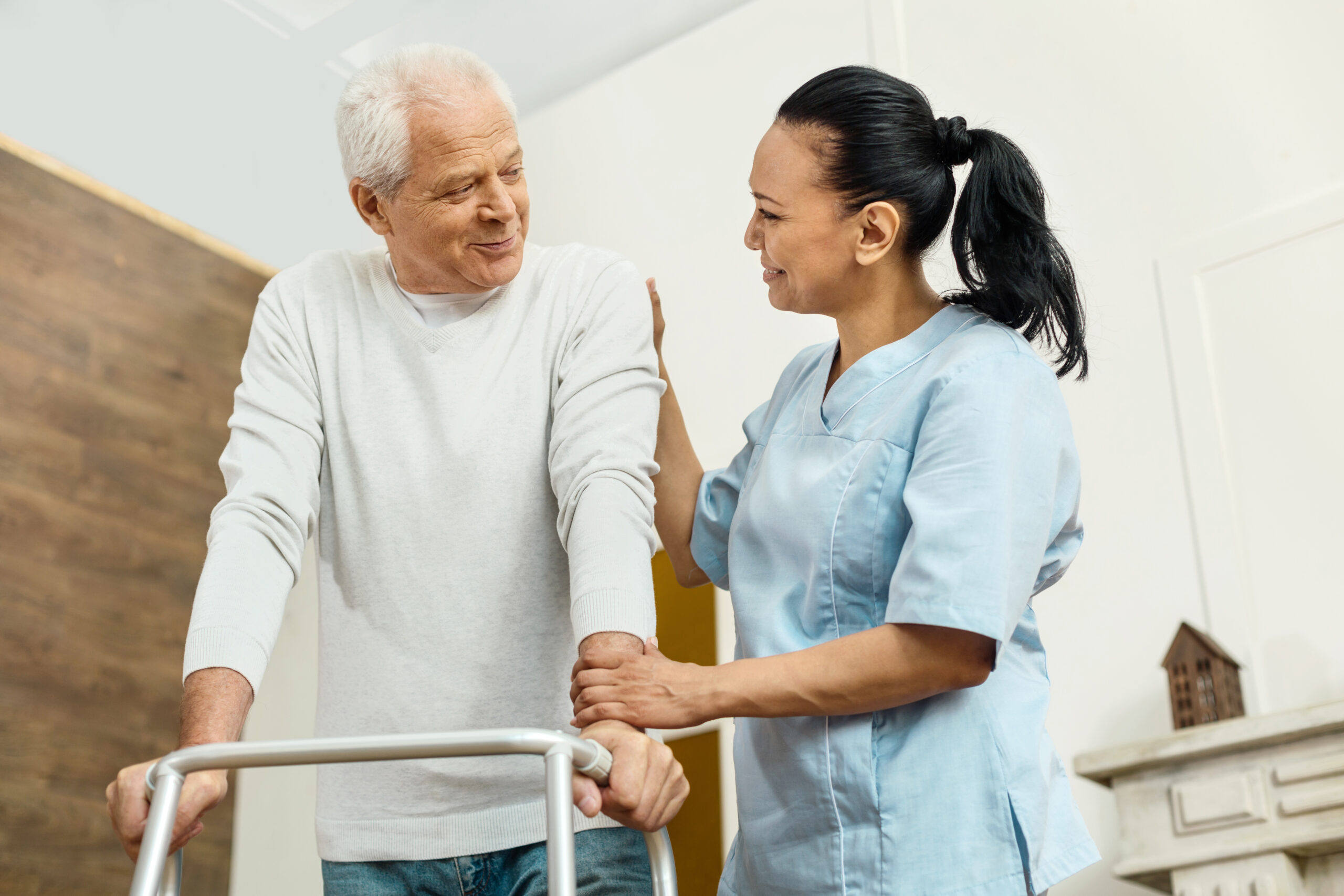 Cheerful friendly nurse helping the elderly man