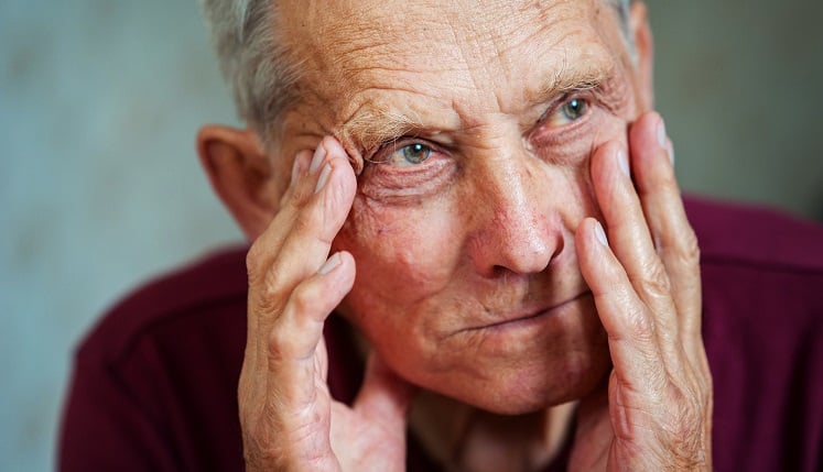 Senior with his hands on his face