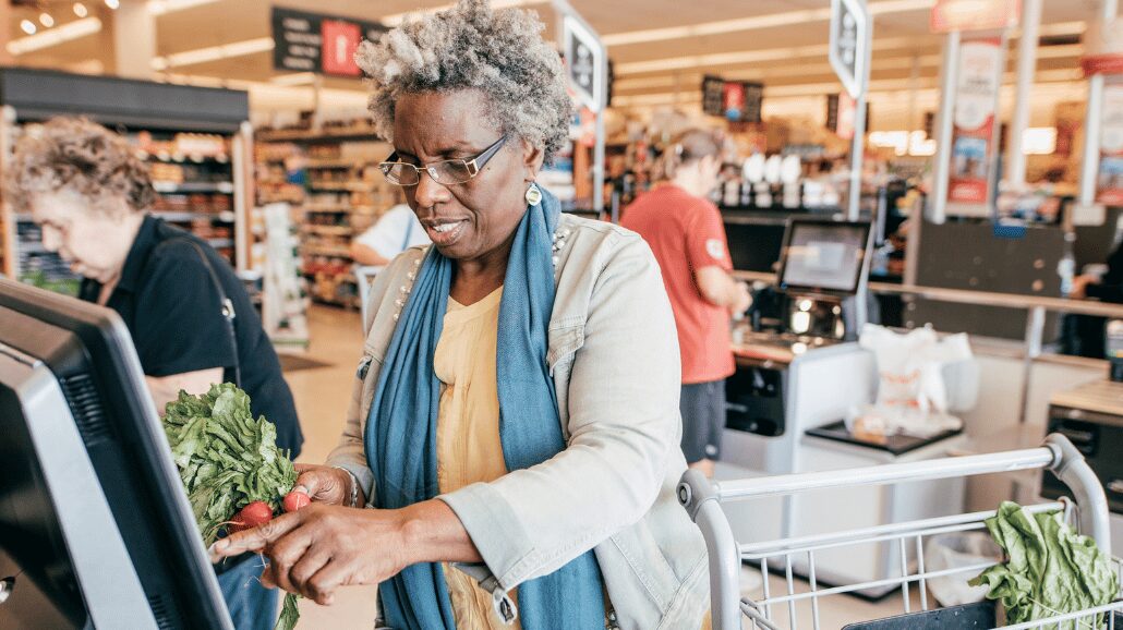 Senior woman at self-checkout in a grocery store