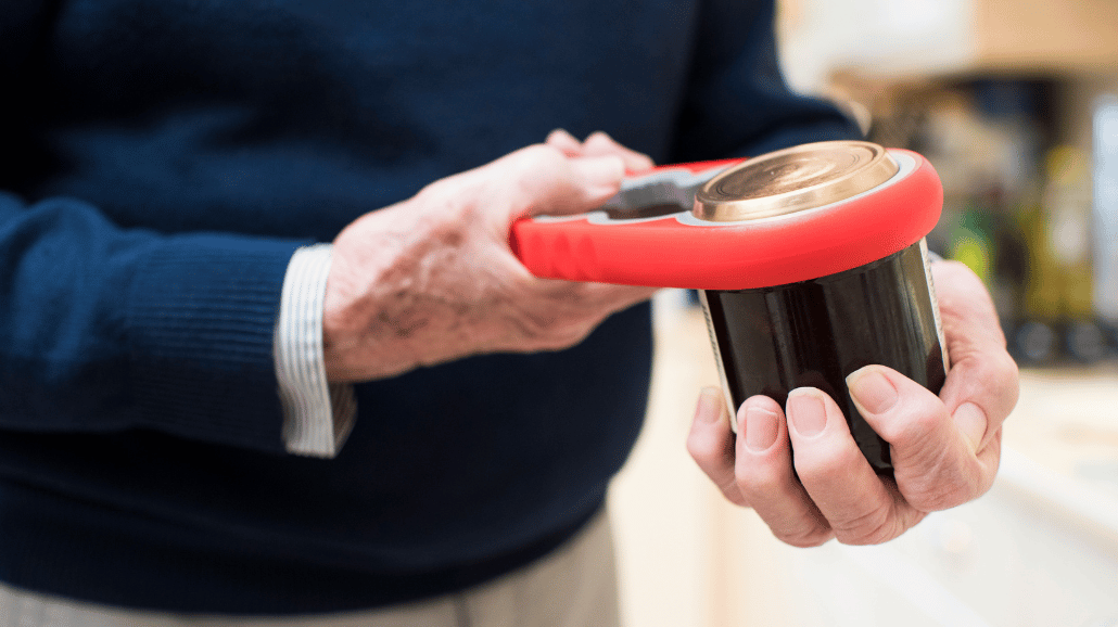 Senior opening a jar with a kitchen tool