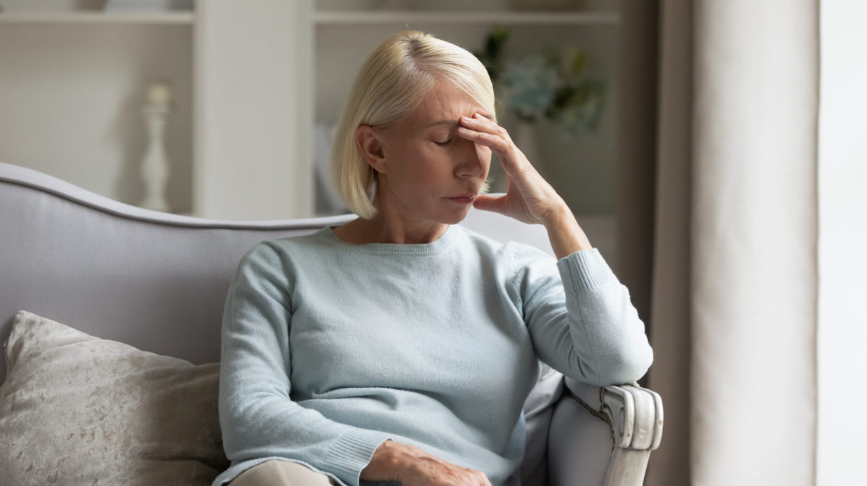 Family caregiver with her hand on her forehead looking sad
