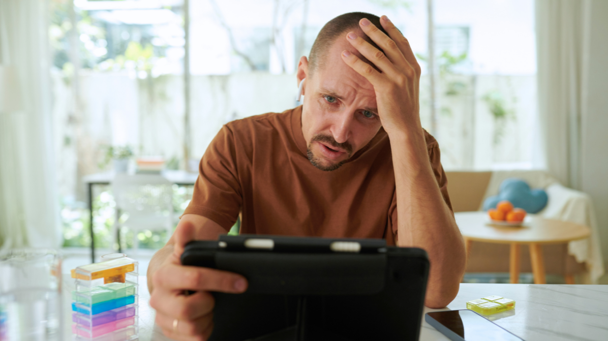 Middle-aged man looking stressed while on video call with family